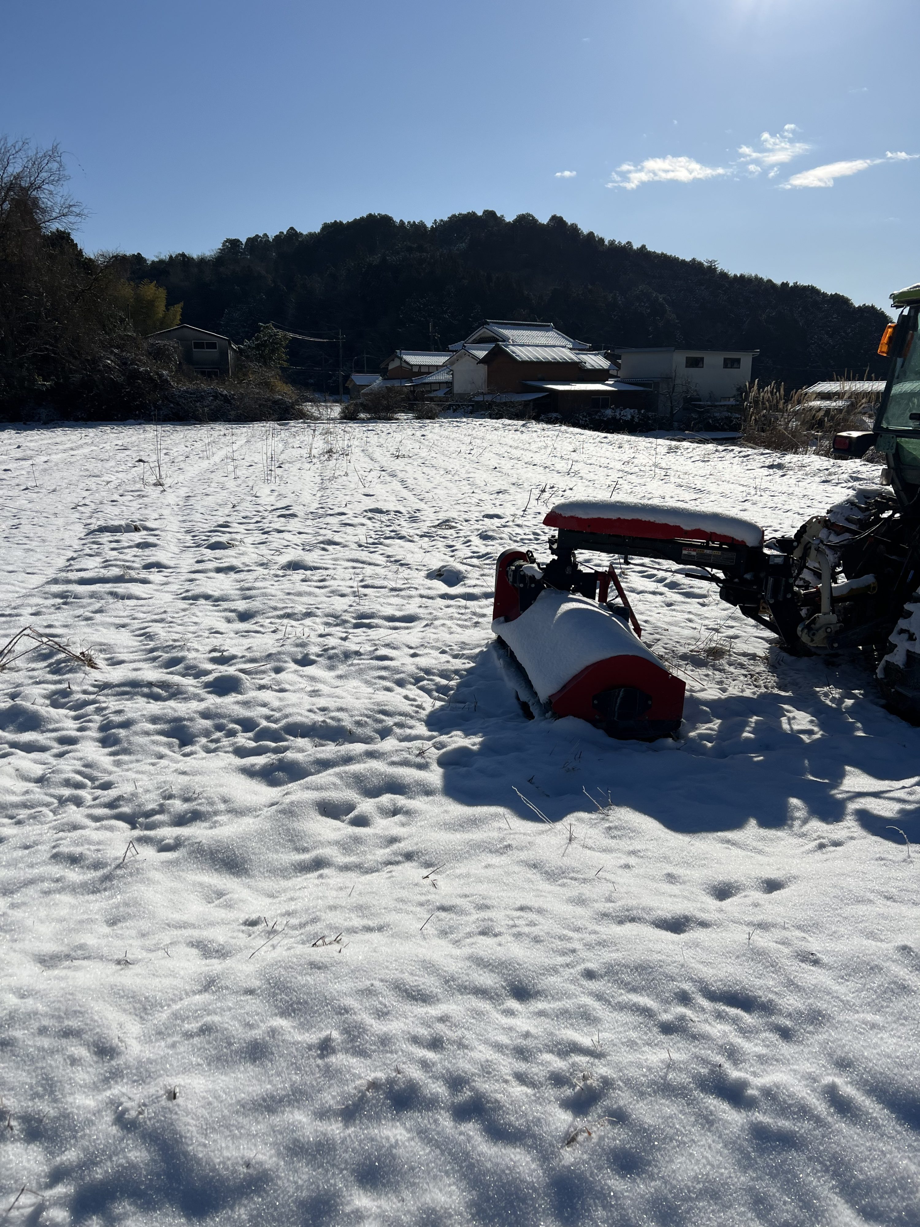 雪に覆われたトラクターと農地